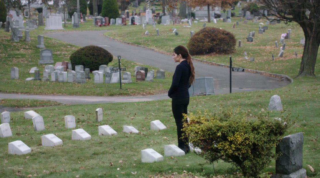 Shaw frente a la tumba de Root