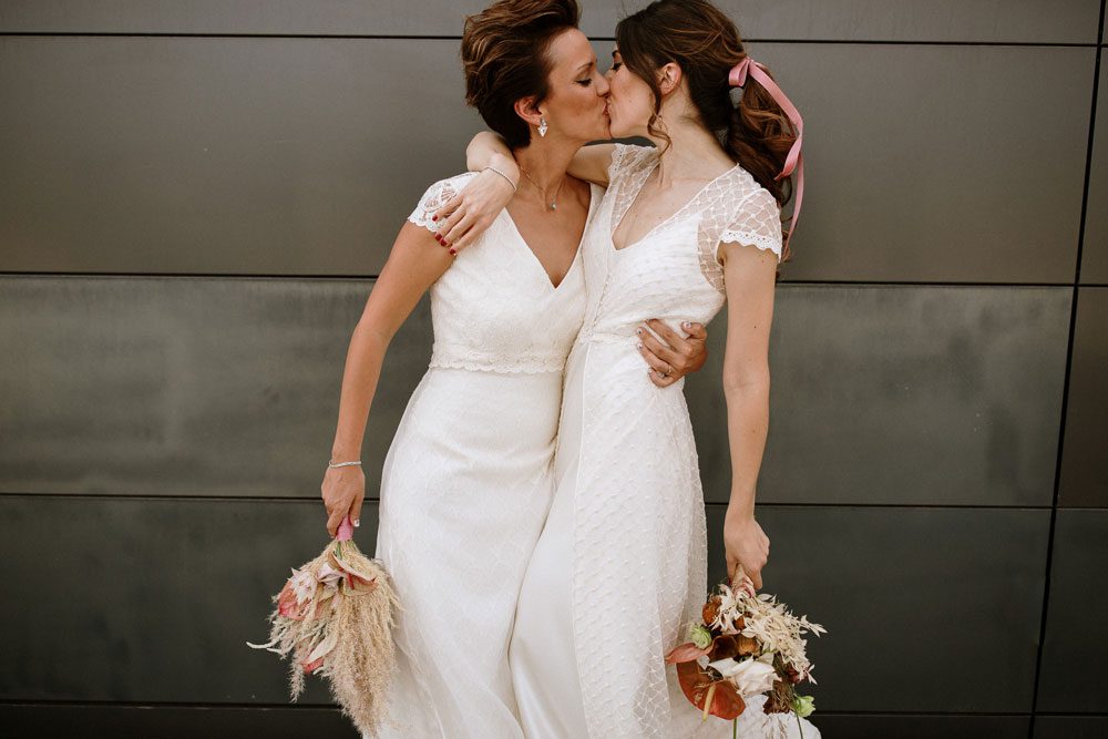 Pareja lésbica besándose el día de su boda