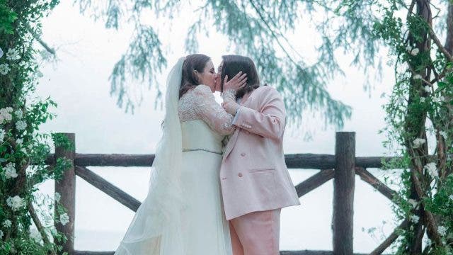 Beanie Feldstein y Bonnie-Chance Robert besándose el día de su boda
